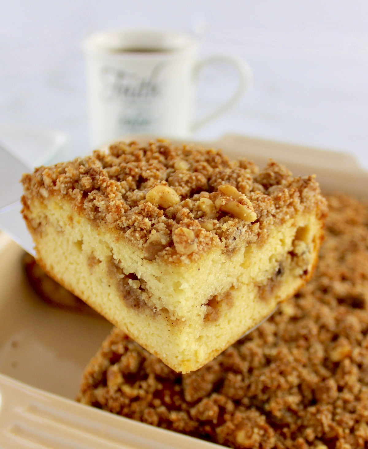 closeup of slice of Keto Coffee Cake held up with silver cake server
