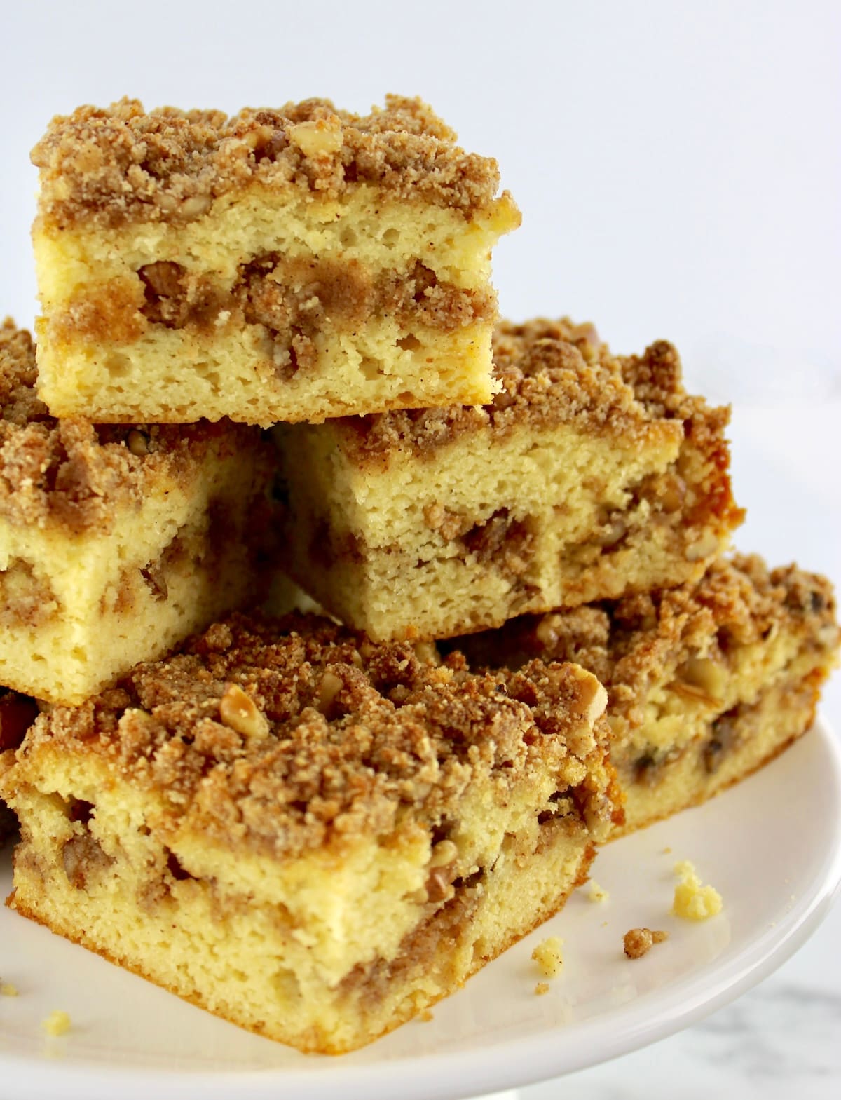 Keto Coffee Cake slices stacked up on white cake platter