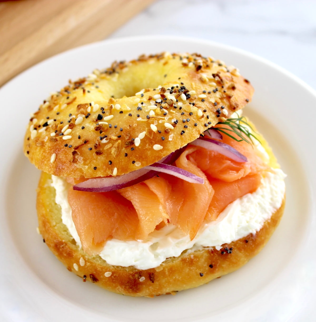 Keto Fathead Bagel with cream cheese and smoked salmon on white plate