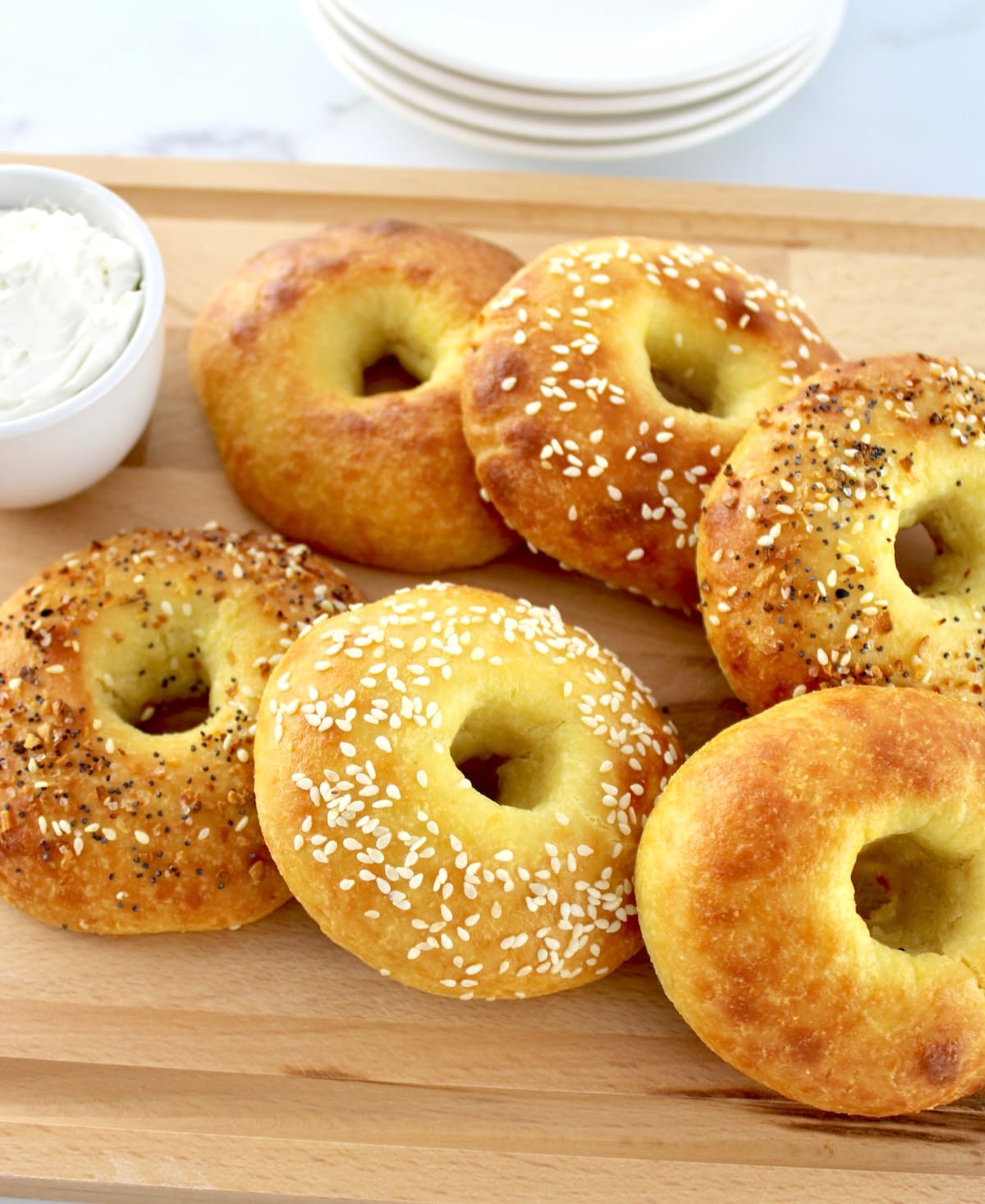 Keto Fathead Bagels on cutting board with cream cheese in white bowl