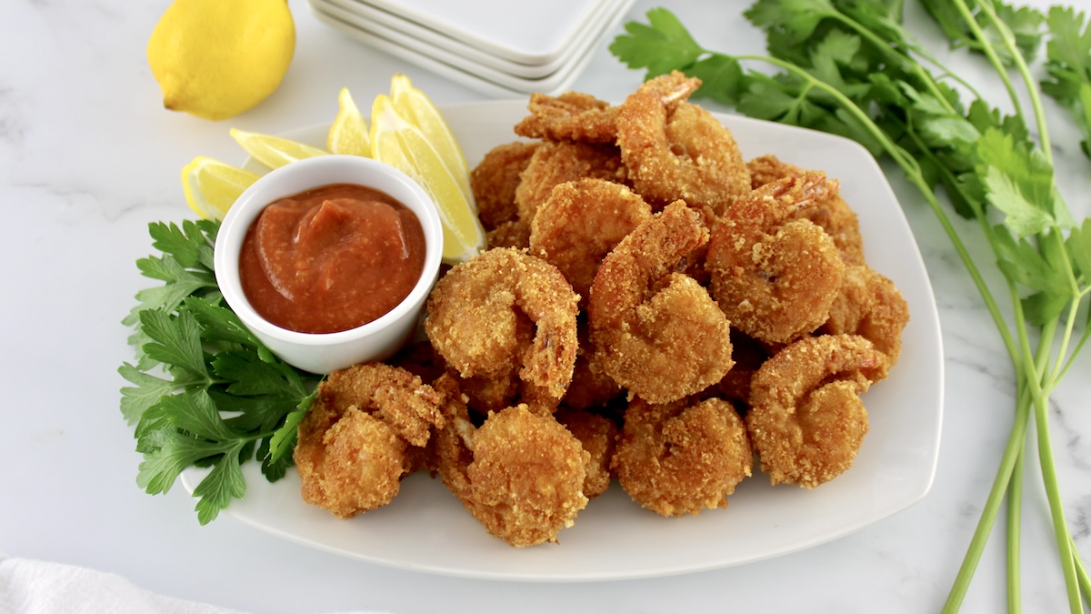 Keto Fried Shrimp with Cocktail Sauce on white dish with lemon and parsley on side