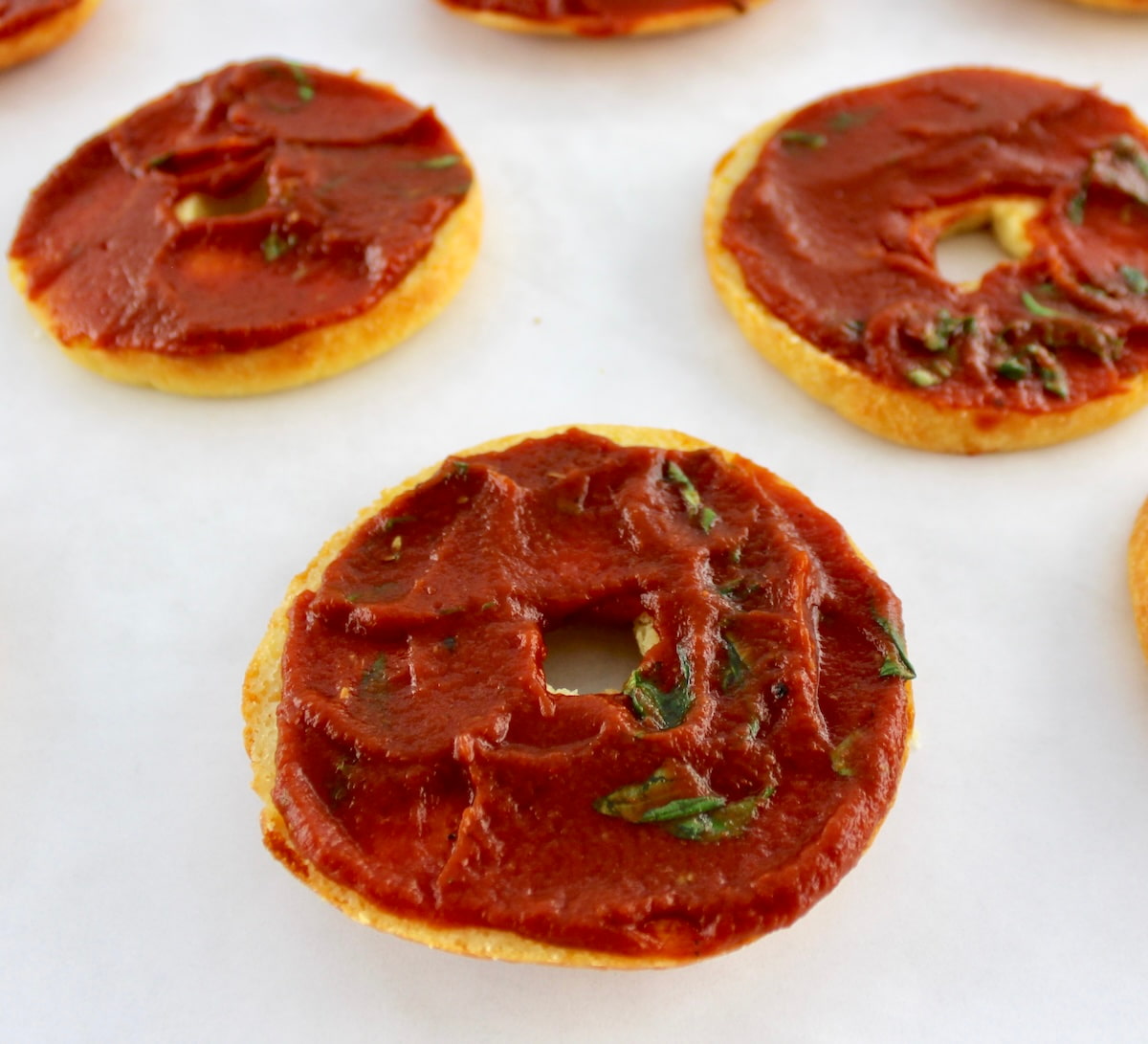 bagel halves with pizza sauce on tops