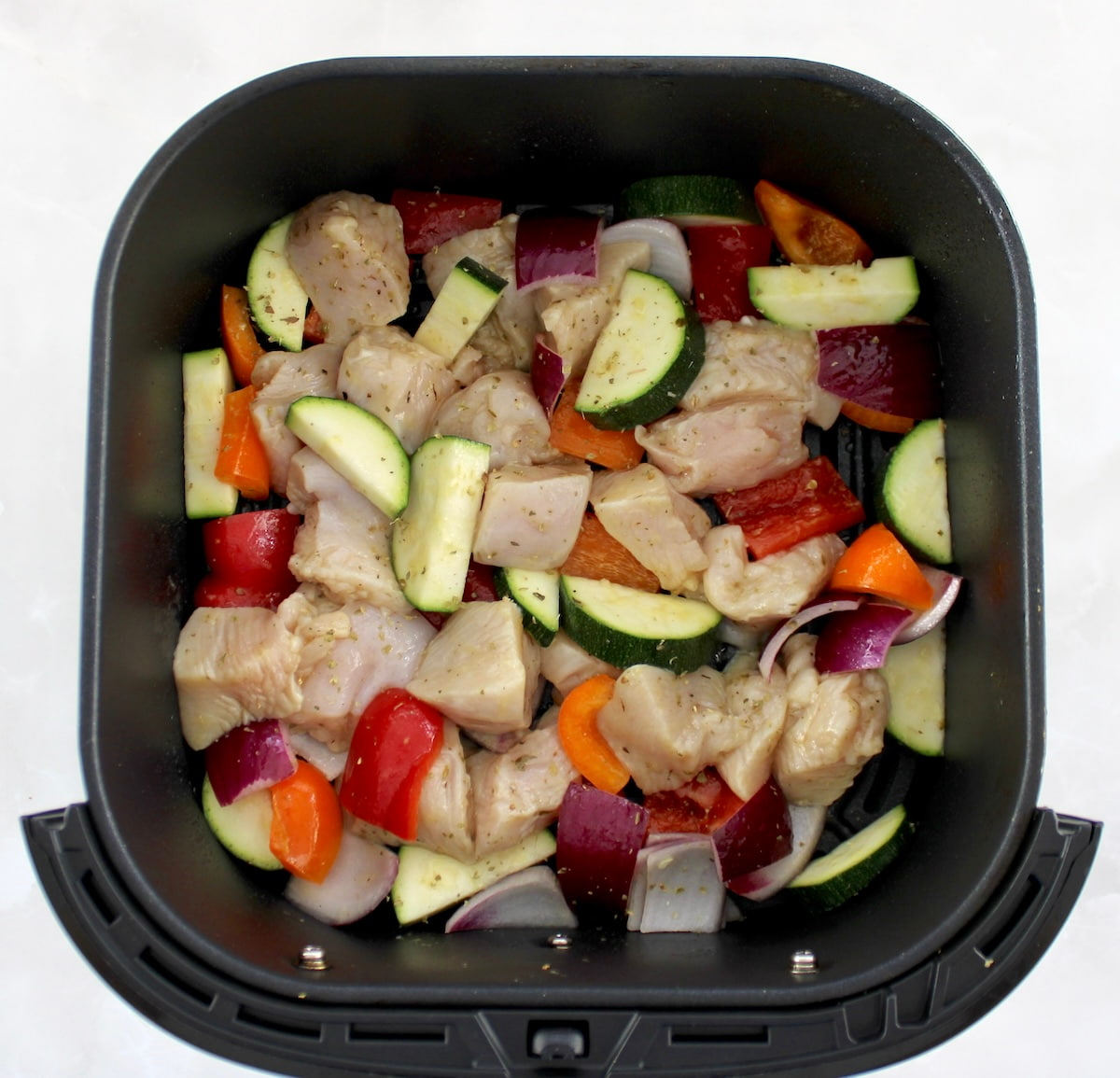 Air Fryer Greek Chicken Bites uncooked in air fryer basket