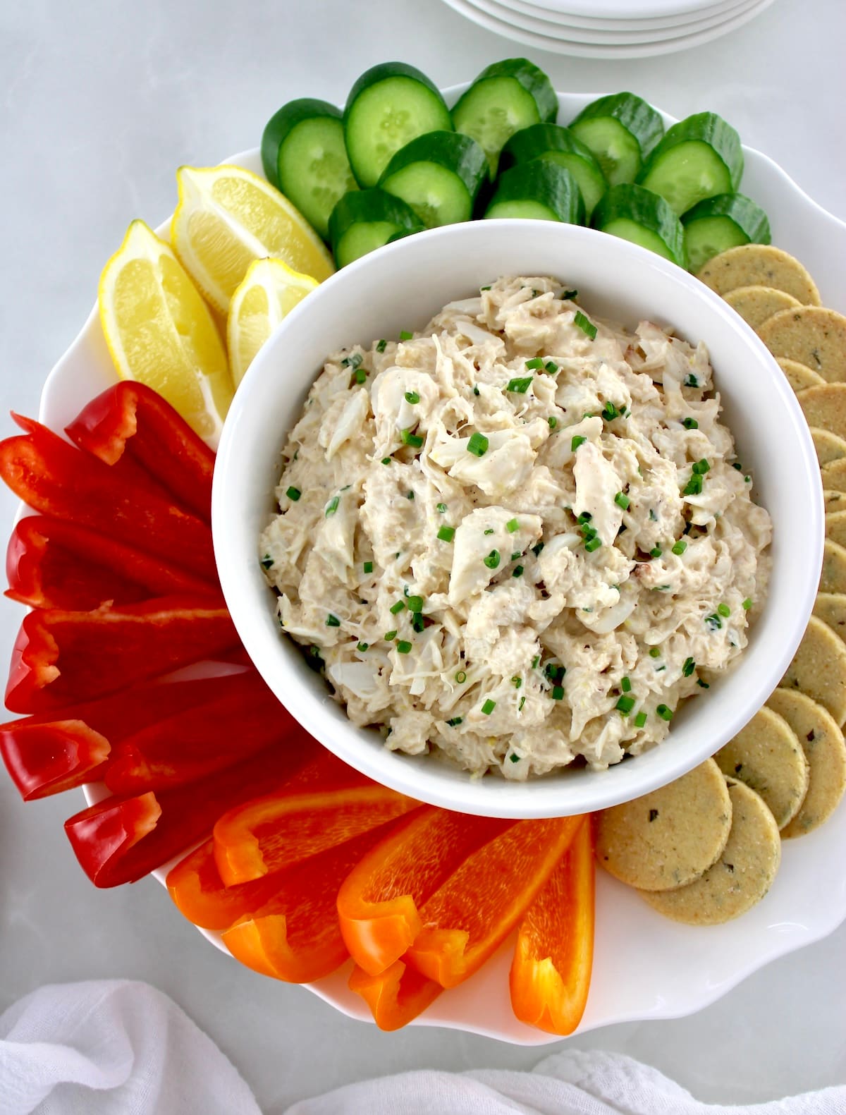 Cold Crab Dip in white bowl with raw veggies and keto crackers around