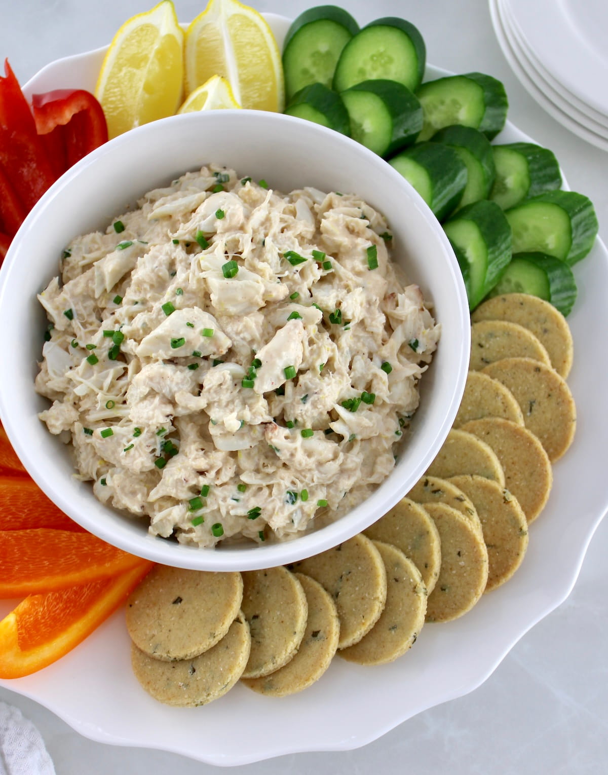 Cold Crab Dip in white bowl with raw veggies and keto crackers around
