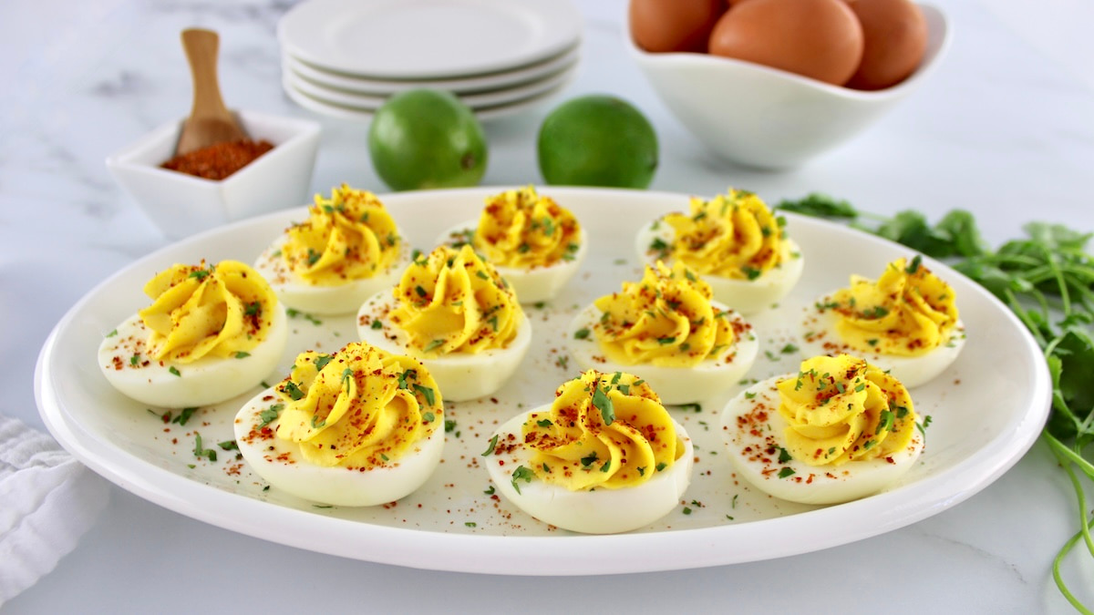 Side horizontal view of Deviled Eggs with Tajín on white platter