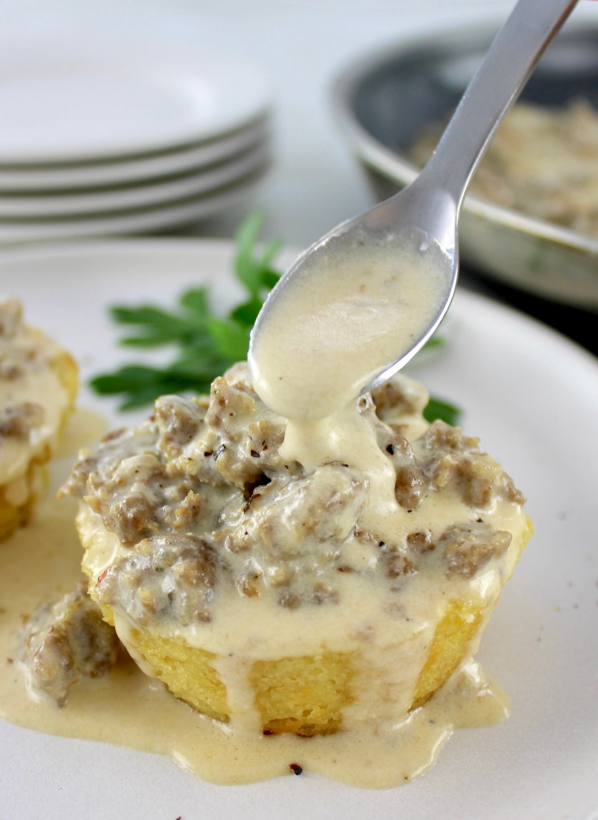 closeup of Keto biscuit with sausage gravy being spooned over top