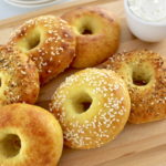 Keto Fathead Bagels on cutting board with cream cheese in white bowl