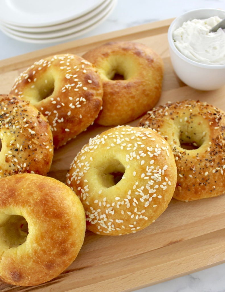 Keto Fathead Bagels on cutting board with cream cheese in white bowl
