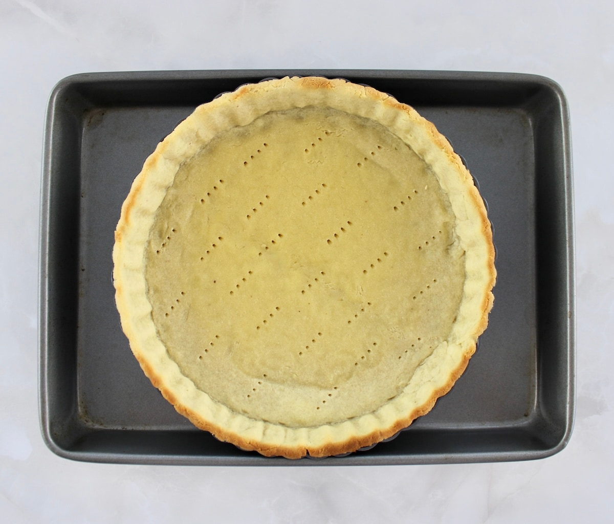 partially cooked keto pie crust on baking sheet