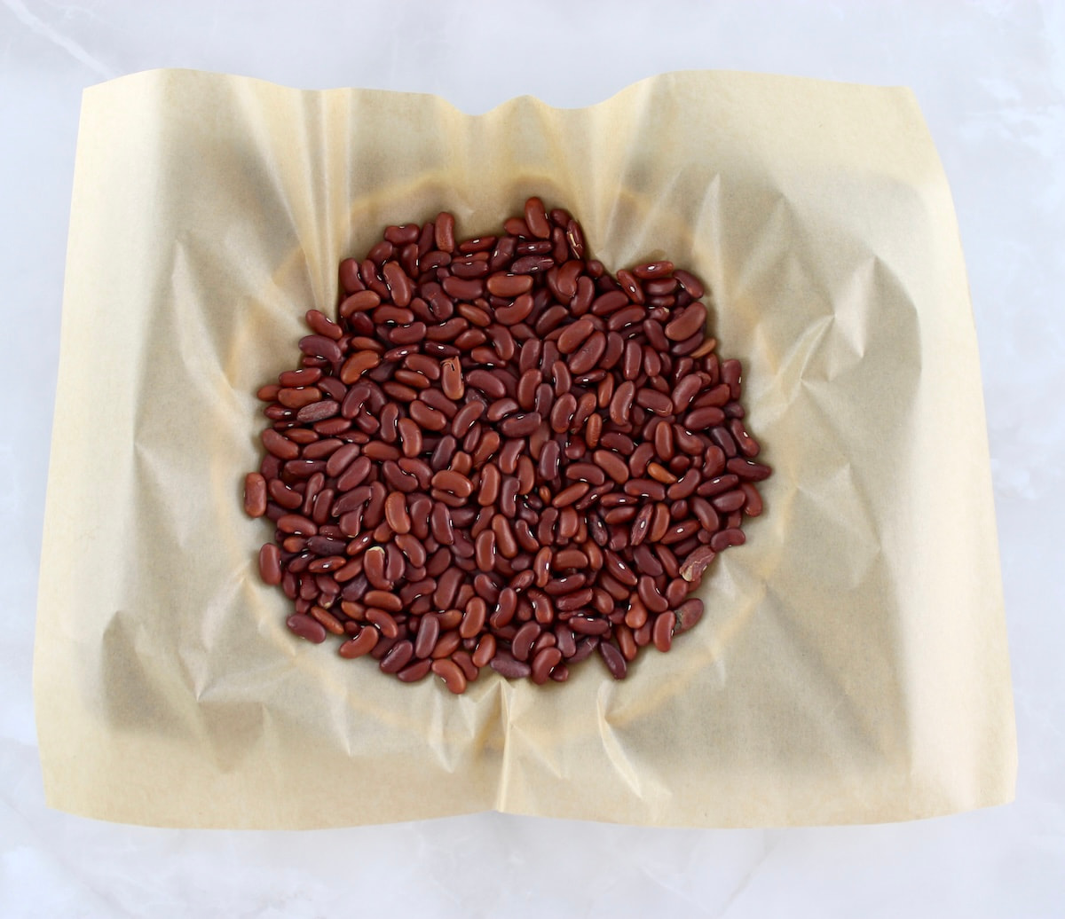 keto pie crust with parchment paper and dried kidney beans on top