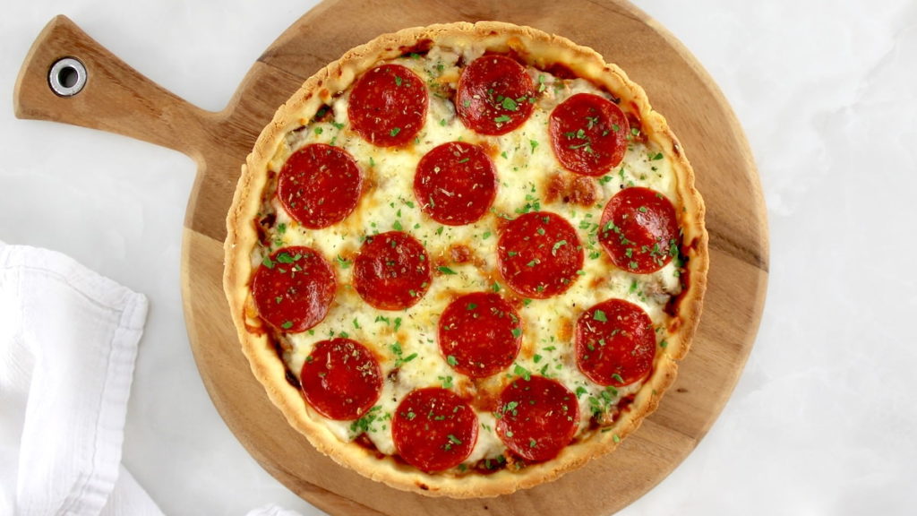 overhead view of Keto Sausage and Pepperoni Pizza Pie on pizza peel