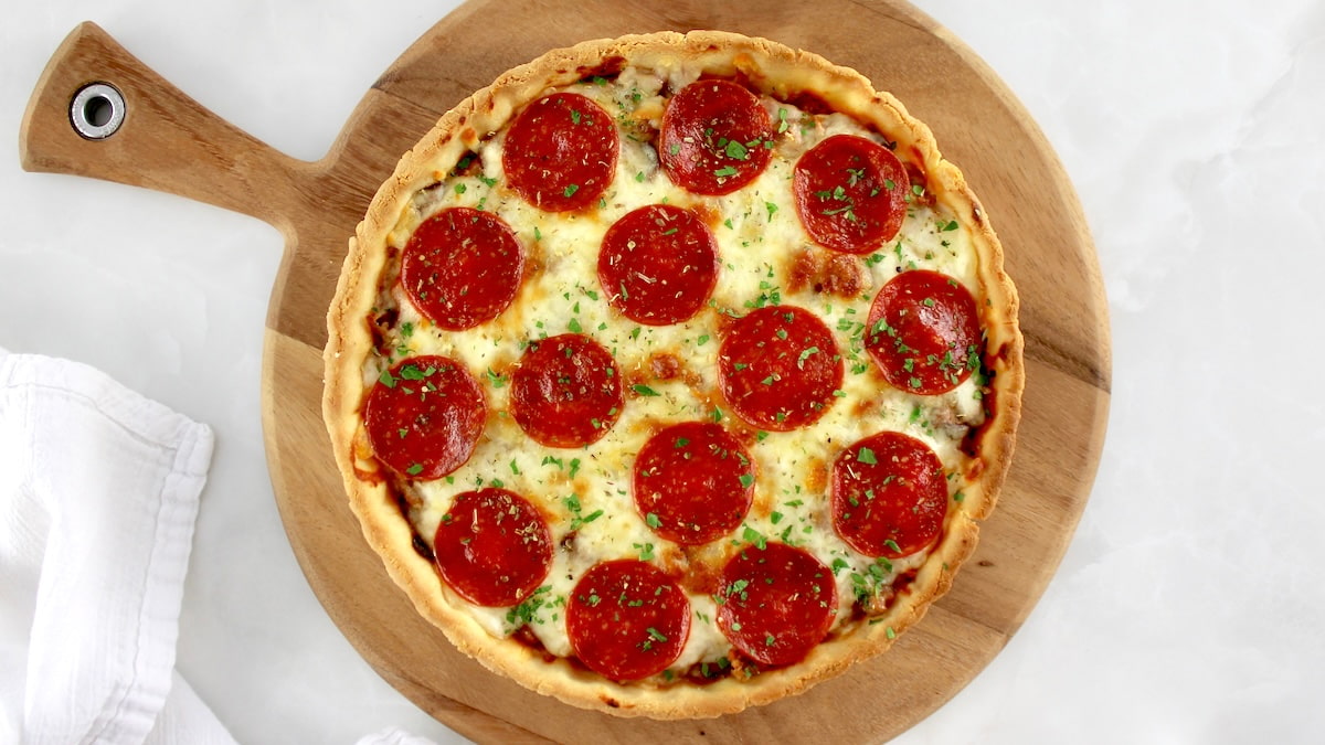 overhead view of Keto Sausage and Pepperoni Pizza Pie on pizza peel