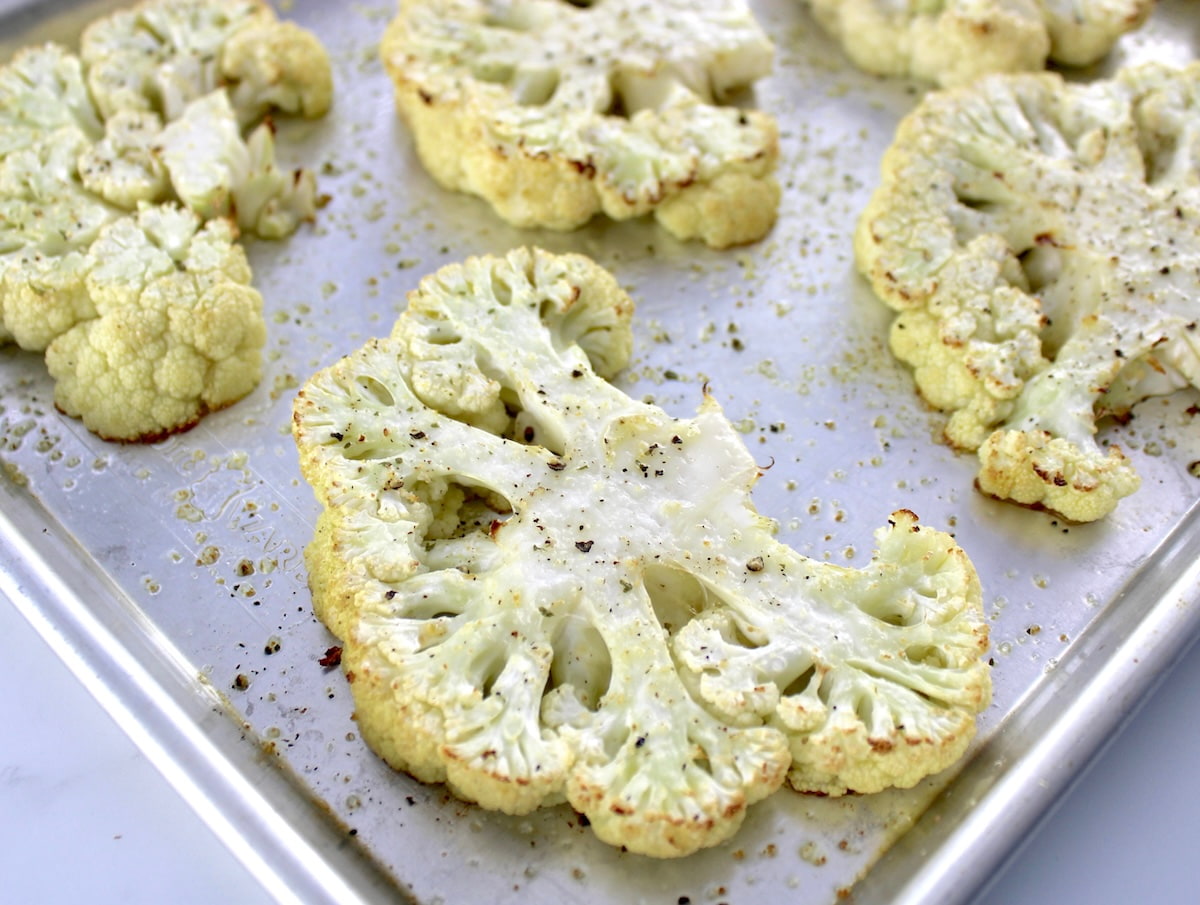 roasted cauliflower steaks on baking sheet