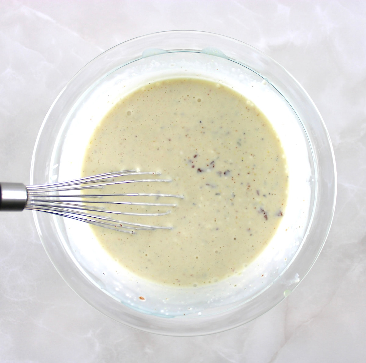 bacon ranch dressing in glass mixing bowl with whisk