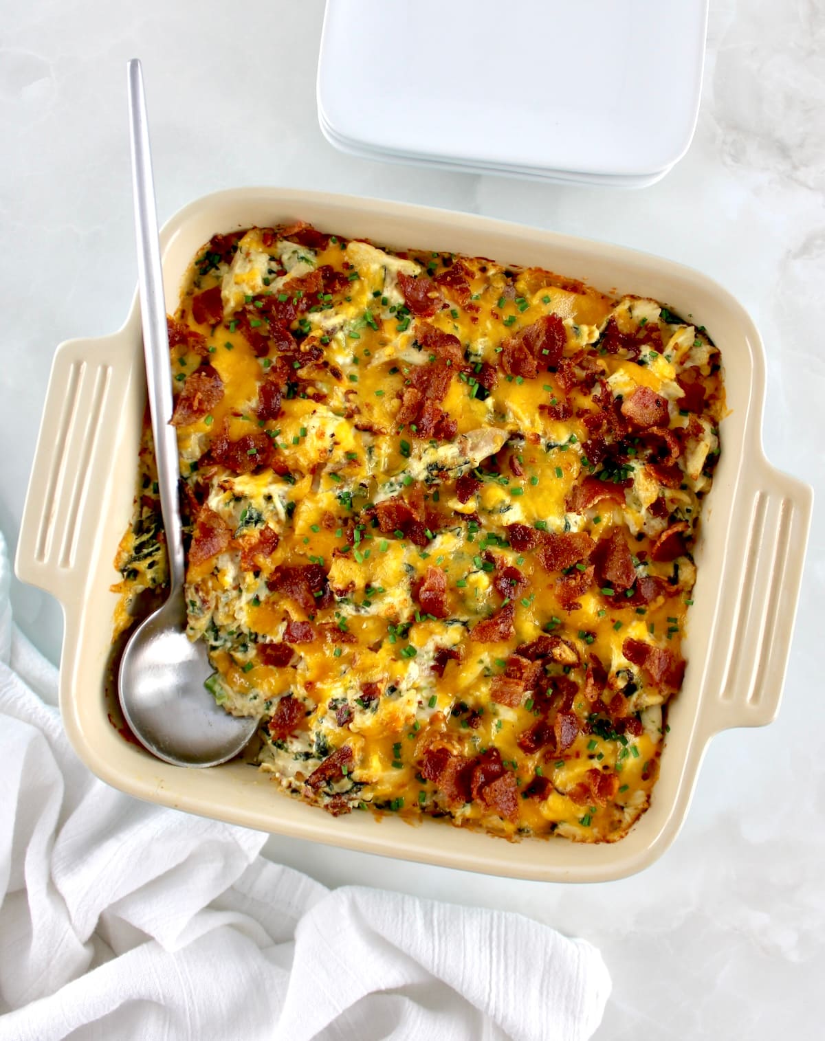 overhead view of Bacon Ranch Chicken Casserole in baking dish with silver serving spoon on side