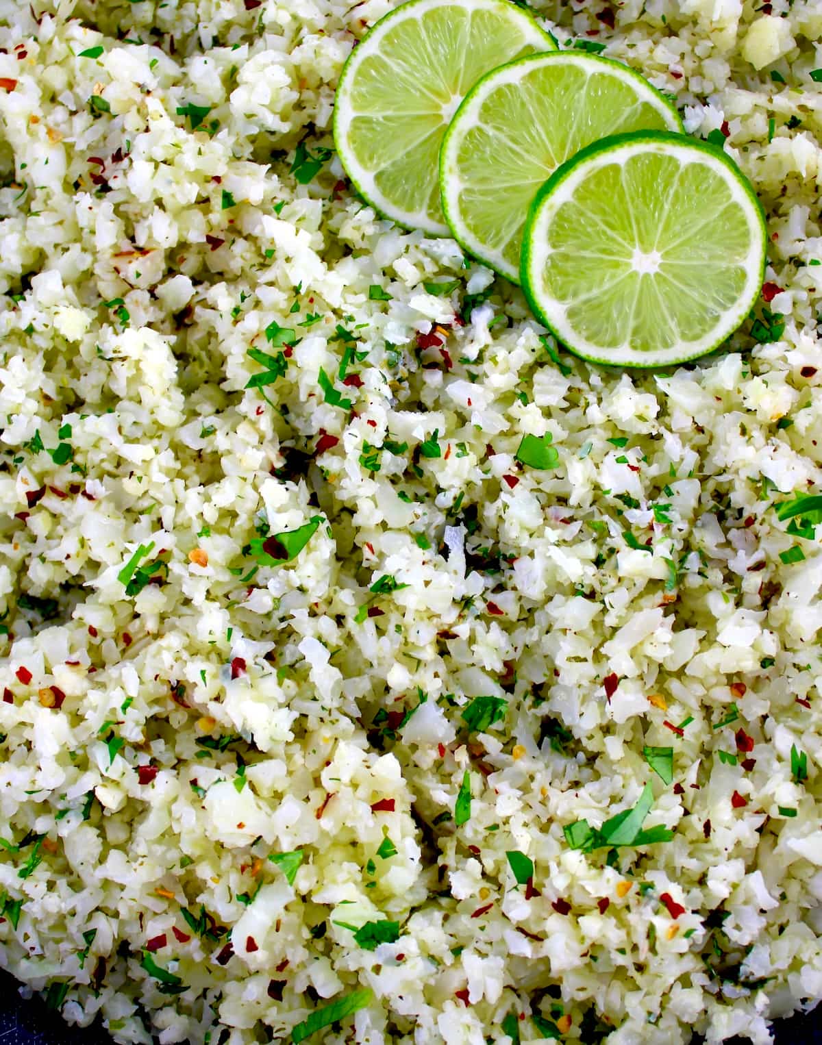 closeup of Chimichurri Cauliflower Rice with 3 lime slices