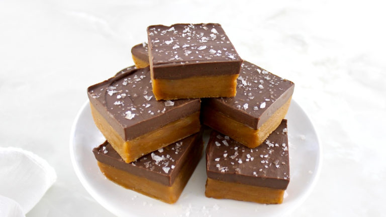 Chocolate Peanut Butter Bars stacked up on white cake stand
