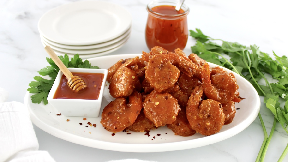 Hot Honey Fried Shrimp on white oval platter with sauce and parsley on side