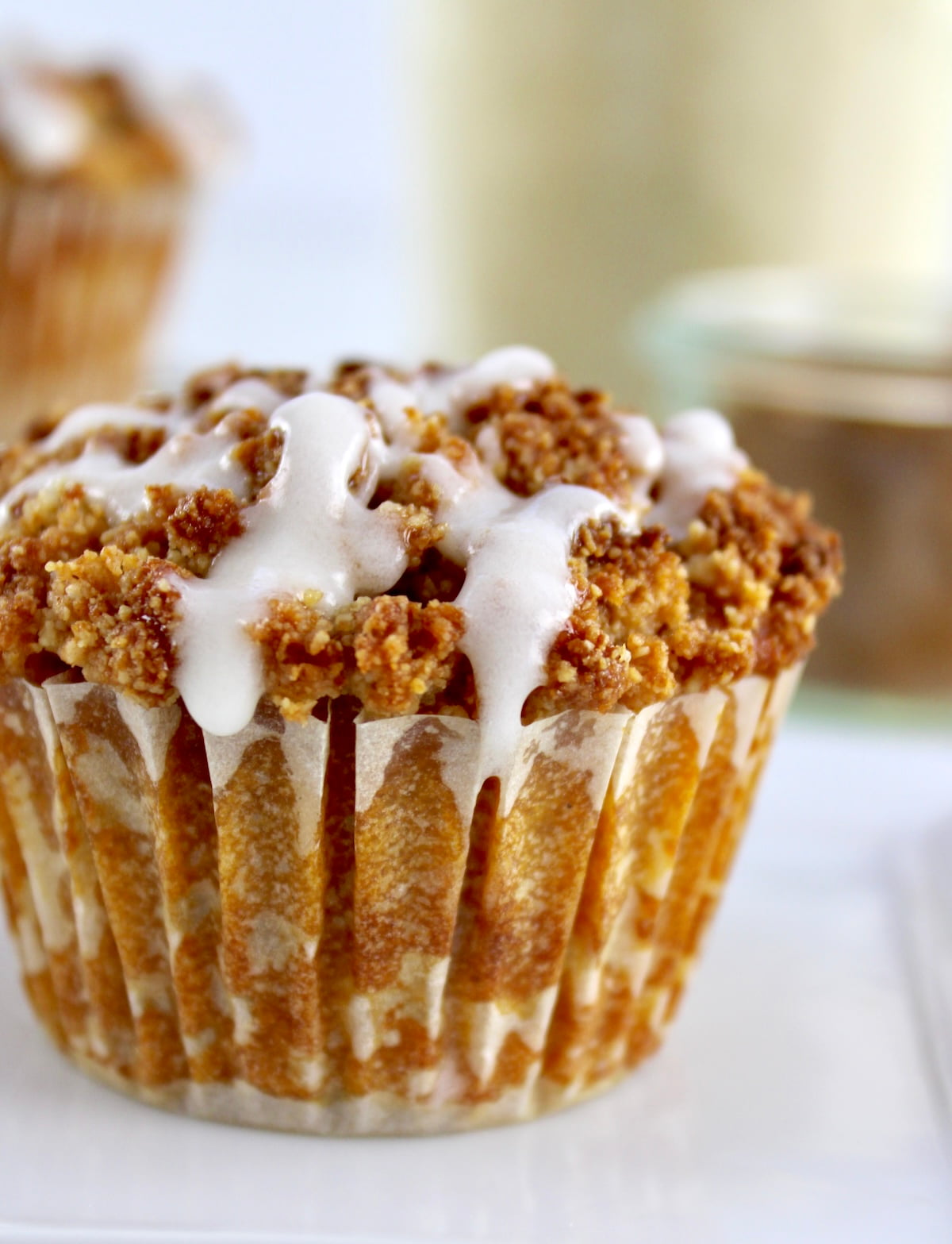 closeup of Keto Pumpkin Coffee Cake Muffin in white dish with icing dripping
