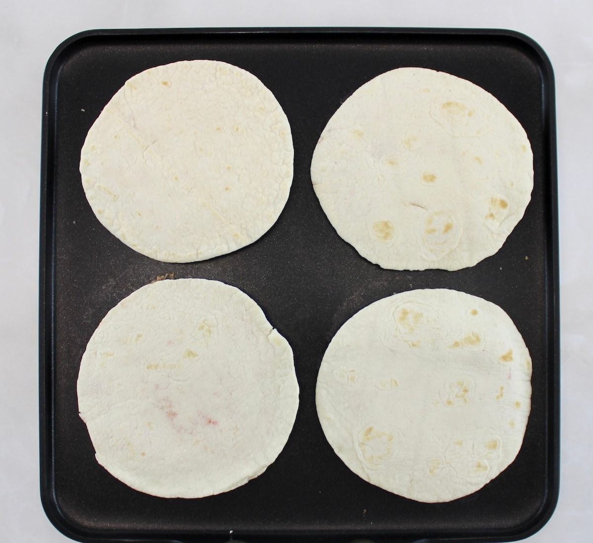 4 Keto Smash Burger Tacos cooking on griddle