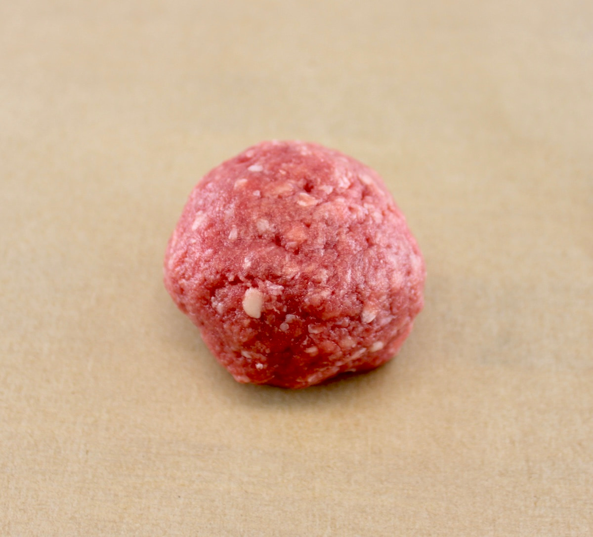 ground beef ball on parchment paper