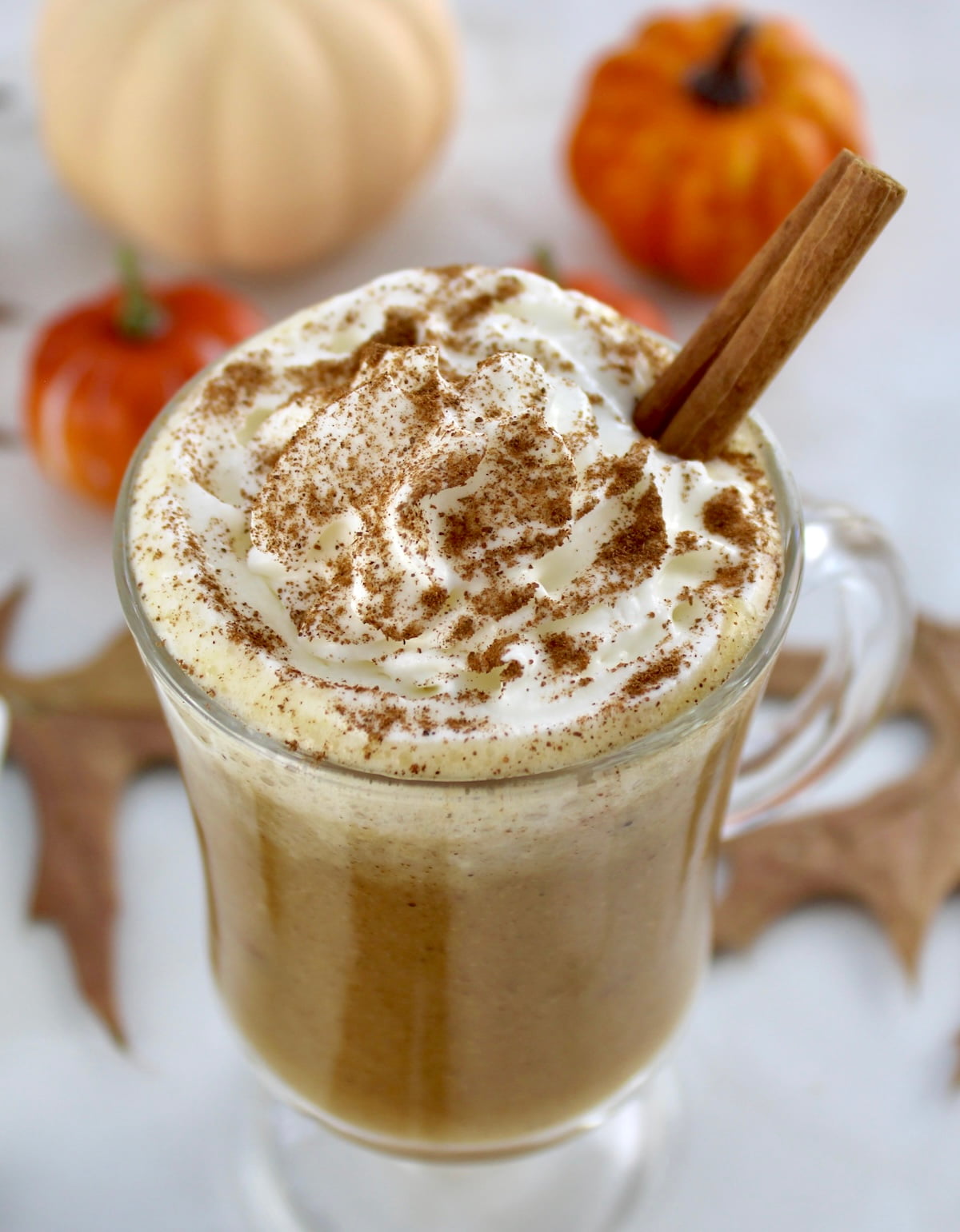 overhead view of Pumpkin Spiced Bulletproof Coffee in glass with whip cream and cinnamon on top
