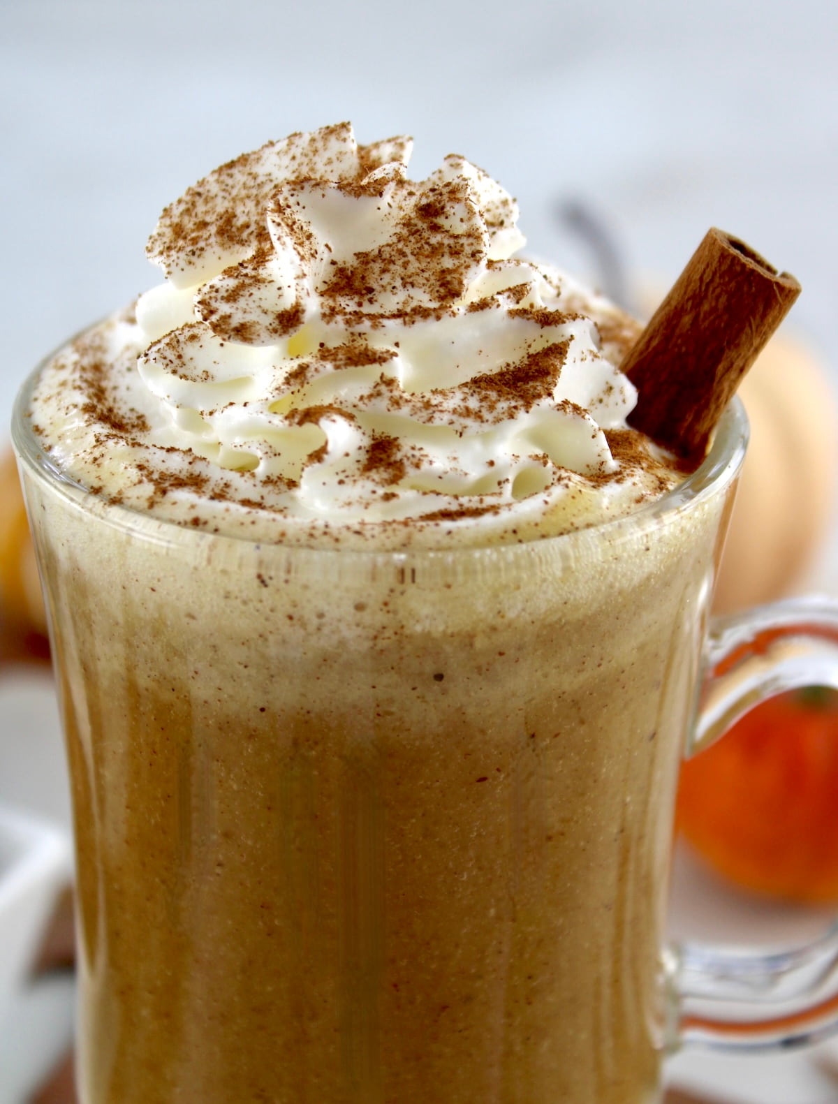 closeup of Pumpkin Spiced Bulletproof Coffee with whip cream on top and cinnamon stick