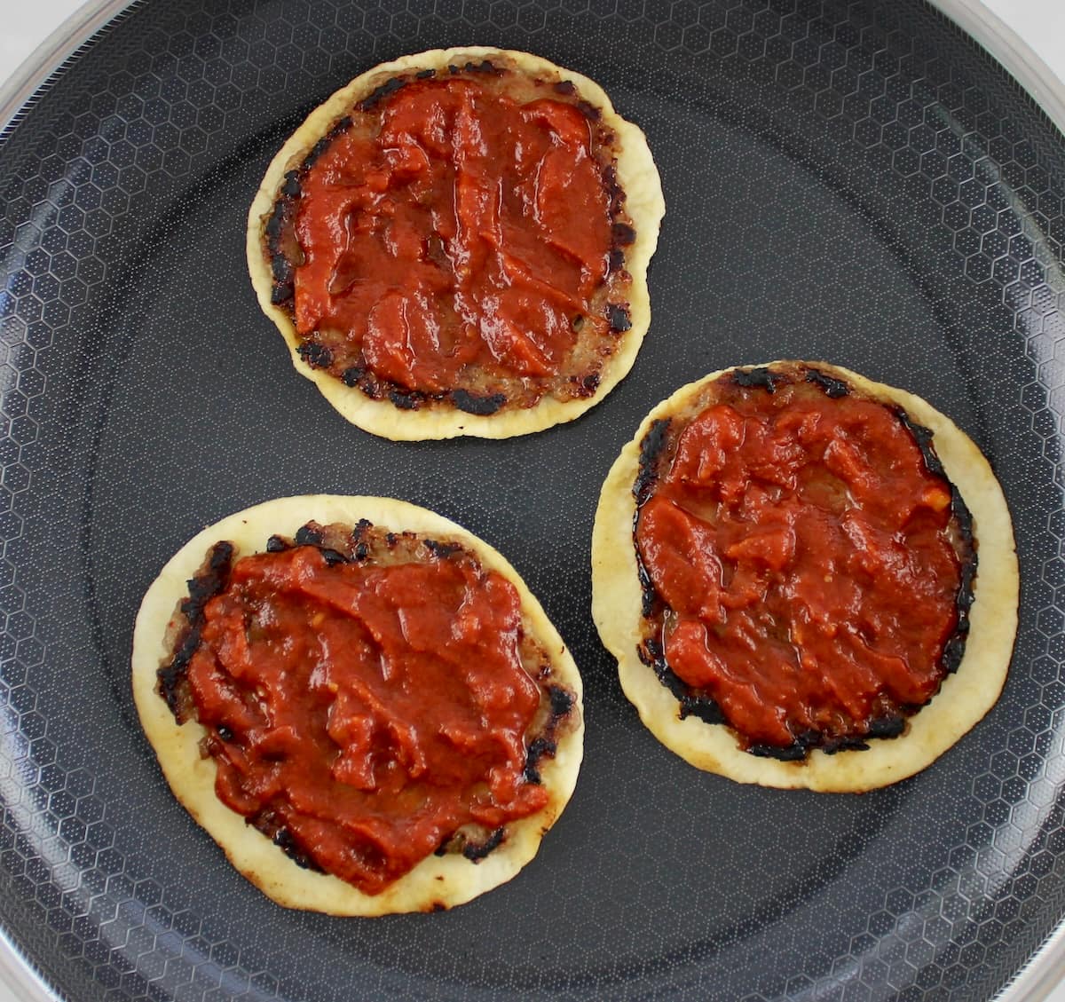 3 Smash Burger Pizza Tacos with pizza sauce on top on skillet