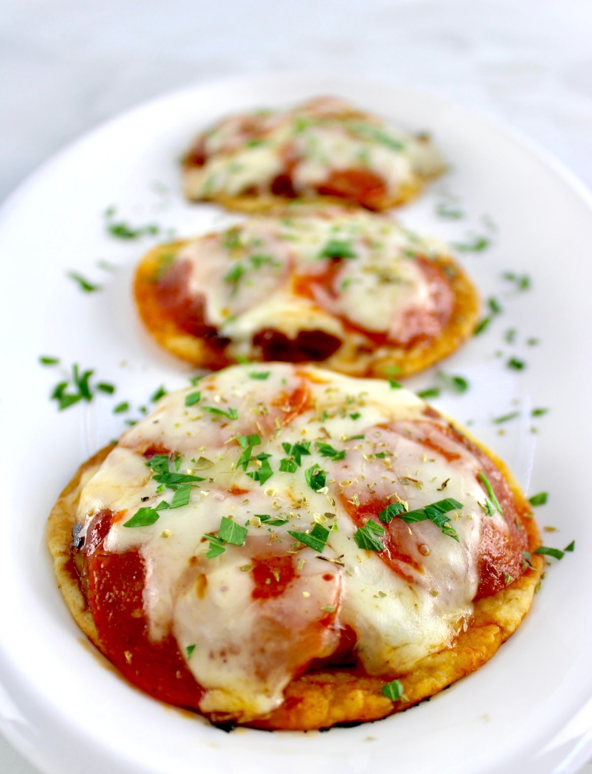 closeup of 3 Smash Burger Pizza Tacos on white oval platter