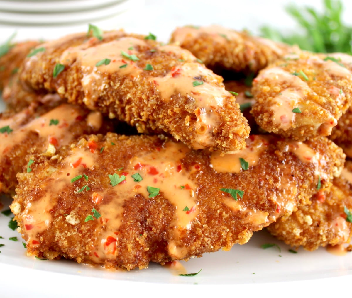 closeup of Bang Bang Chicken Tenders stacked on white plate