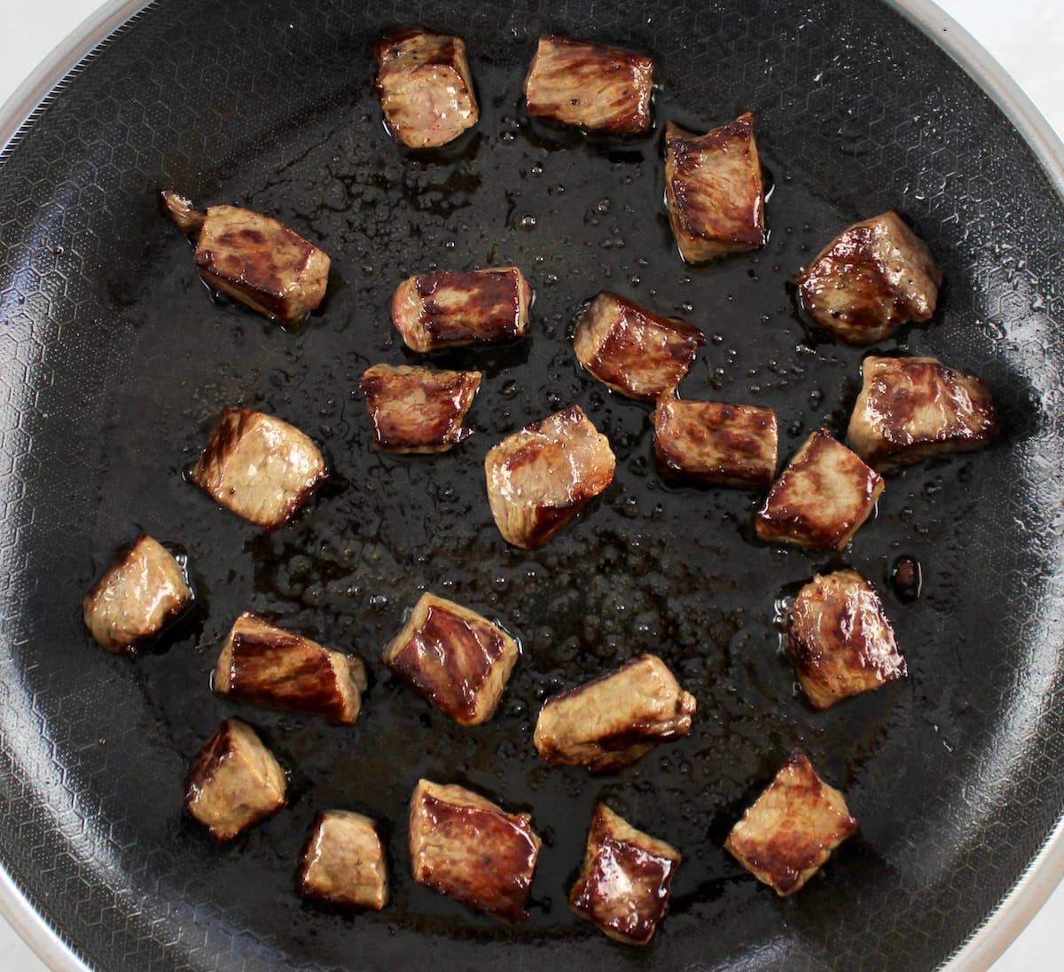 sauteed steak cut into in cubes in skillet