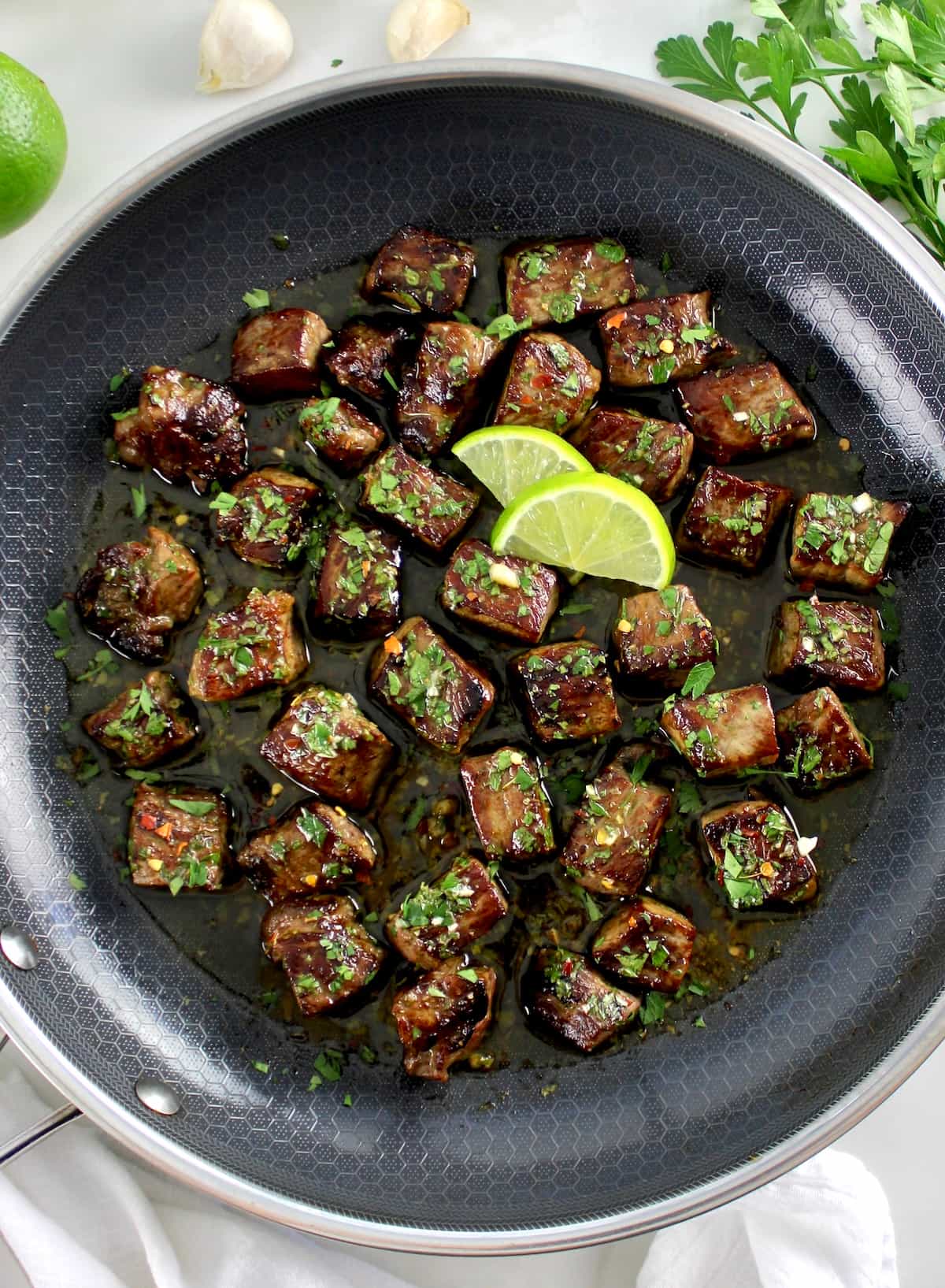 Chimichurri Steak Bites in skillet with 2 lime sauces