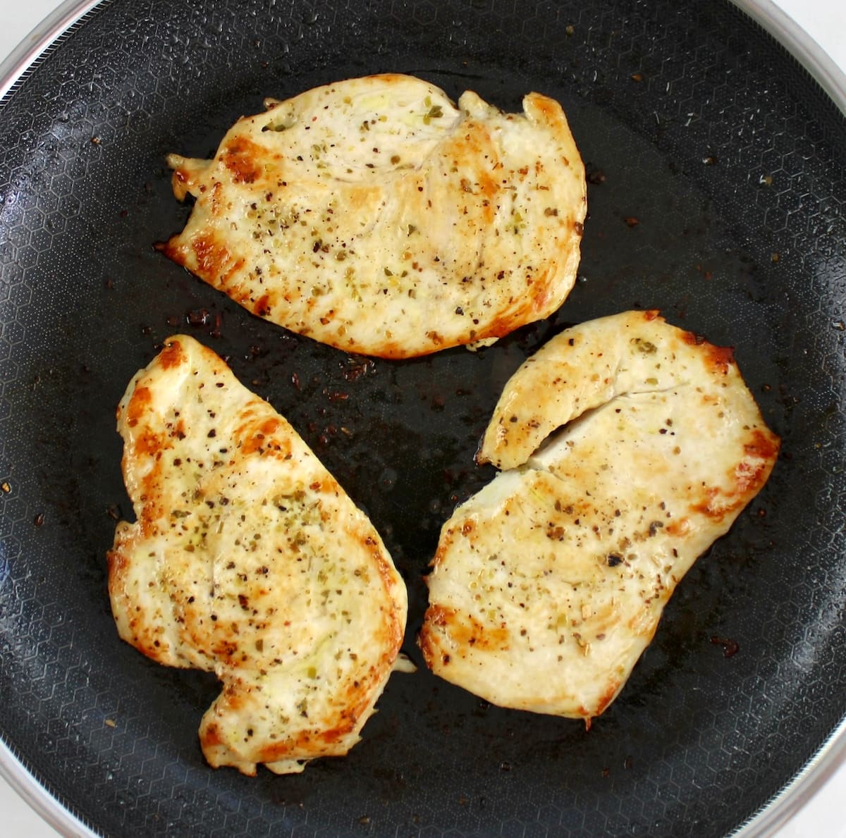 3 pieces of cooked chicken breast in skillet