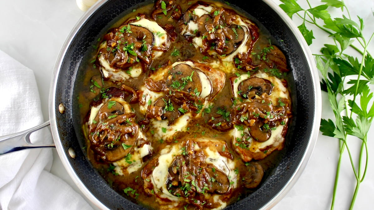 6 pork chops in a pan smothered with french onion toppings