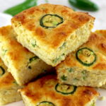 slices of Keto Cheddar Jalapeño Cornbread stacked up on white plate