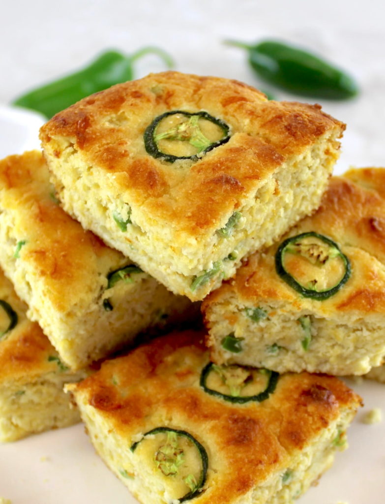slices of Keto Cheddar Jalapeño Cornbread stacked up on white plate