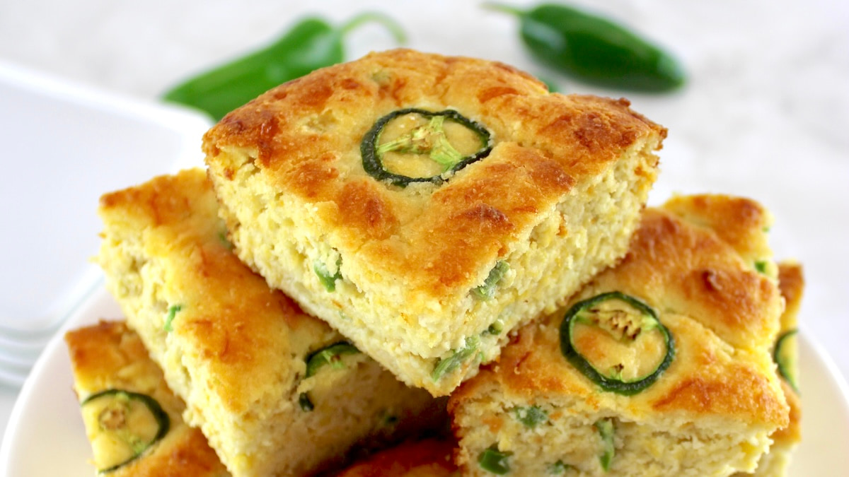 slices of Keto Cheddar Jalapeño Cornbread stacked up on white plate