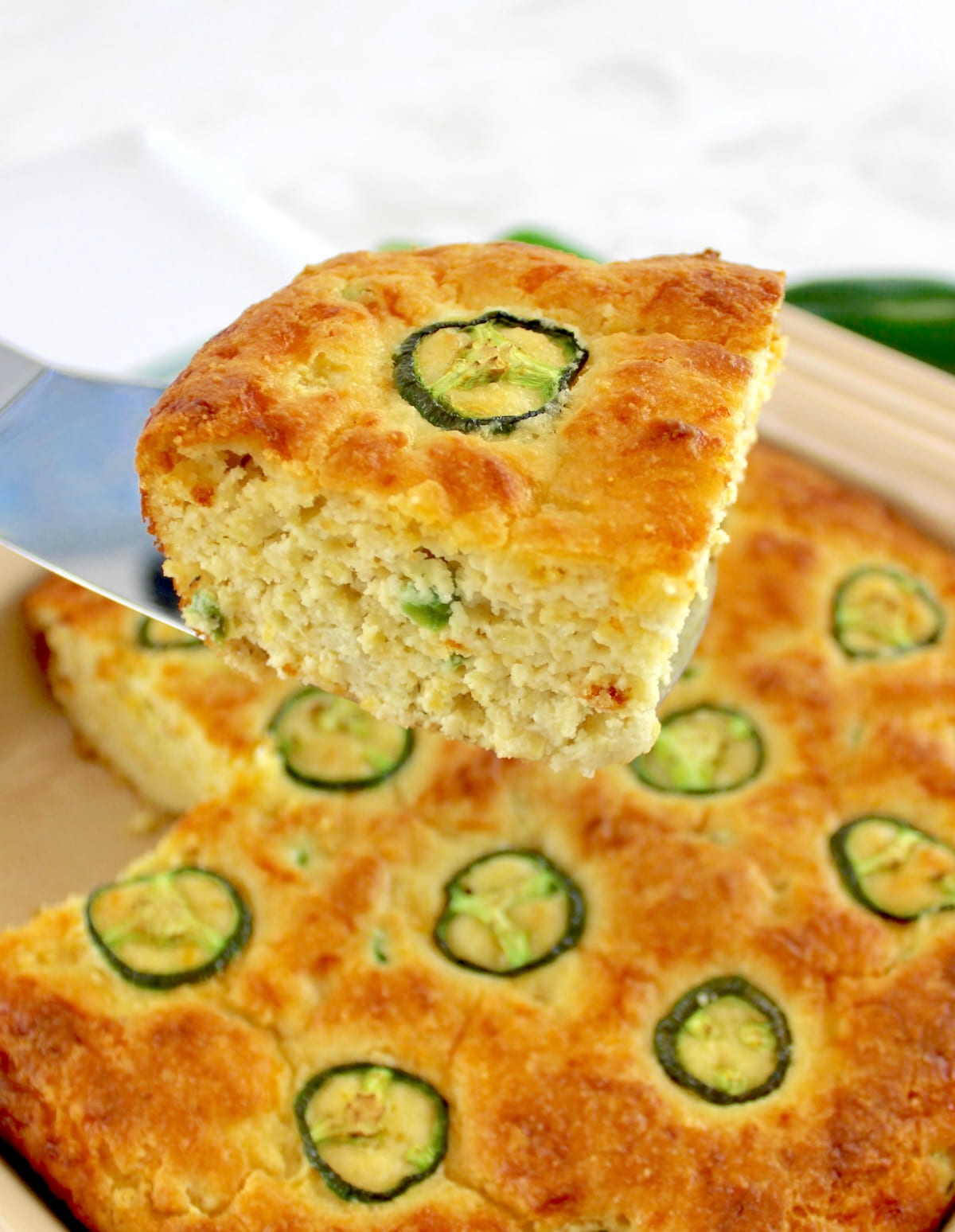 holding up slice of Keto Cheddar Jalapeño Cornbread