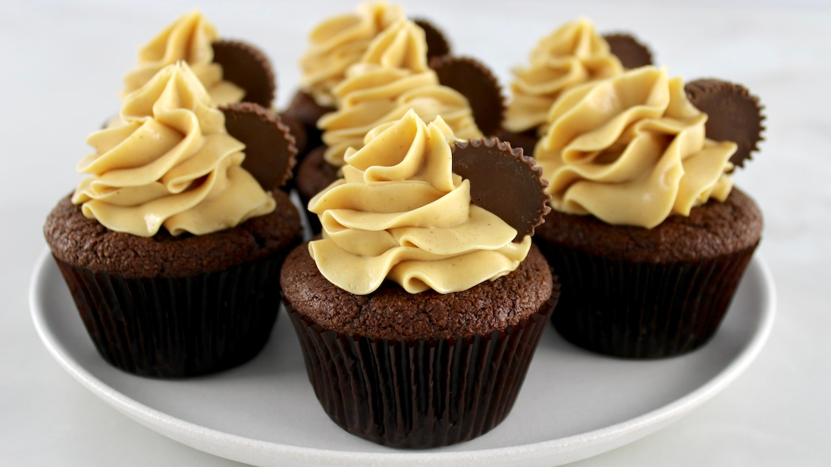 Keto Chocolate Cupcakes with Peanut Butter Frosting on a white cake stand
