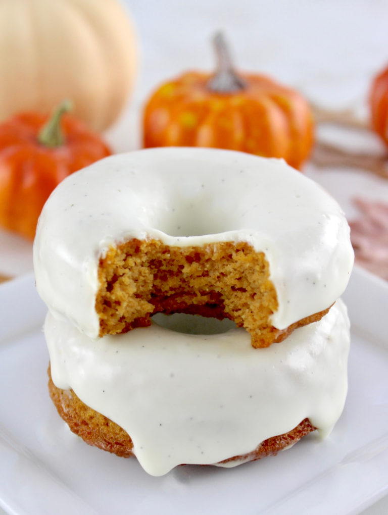 closeup of 2 Keto Pumpkin Donuts stacked and bite taken out of top donut
