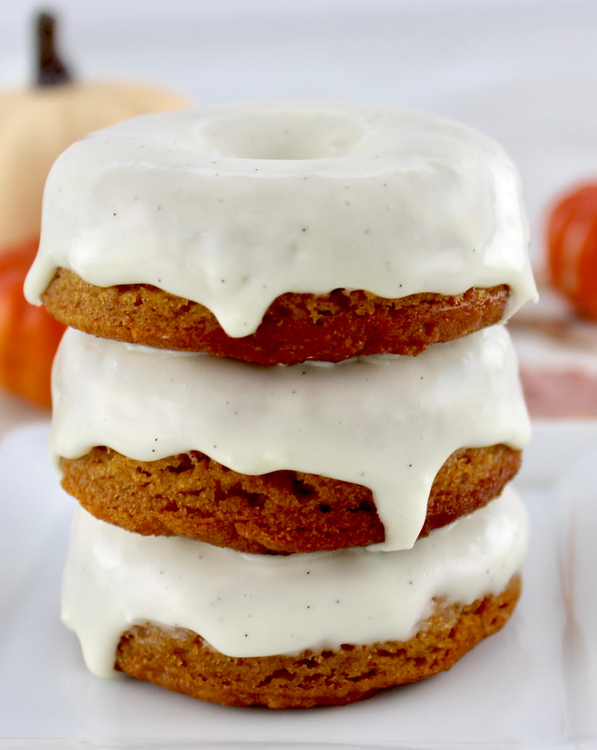 side view of 3 donuts stacked up with frosting