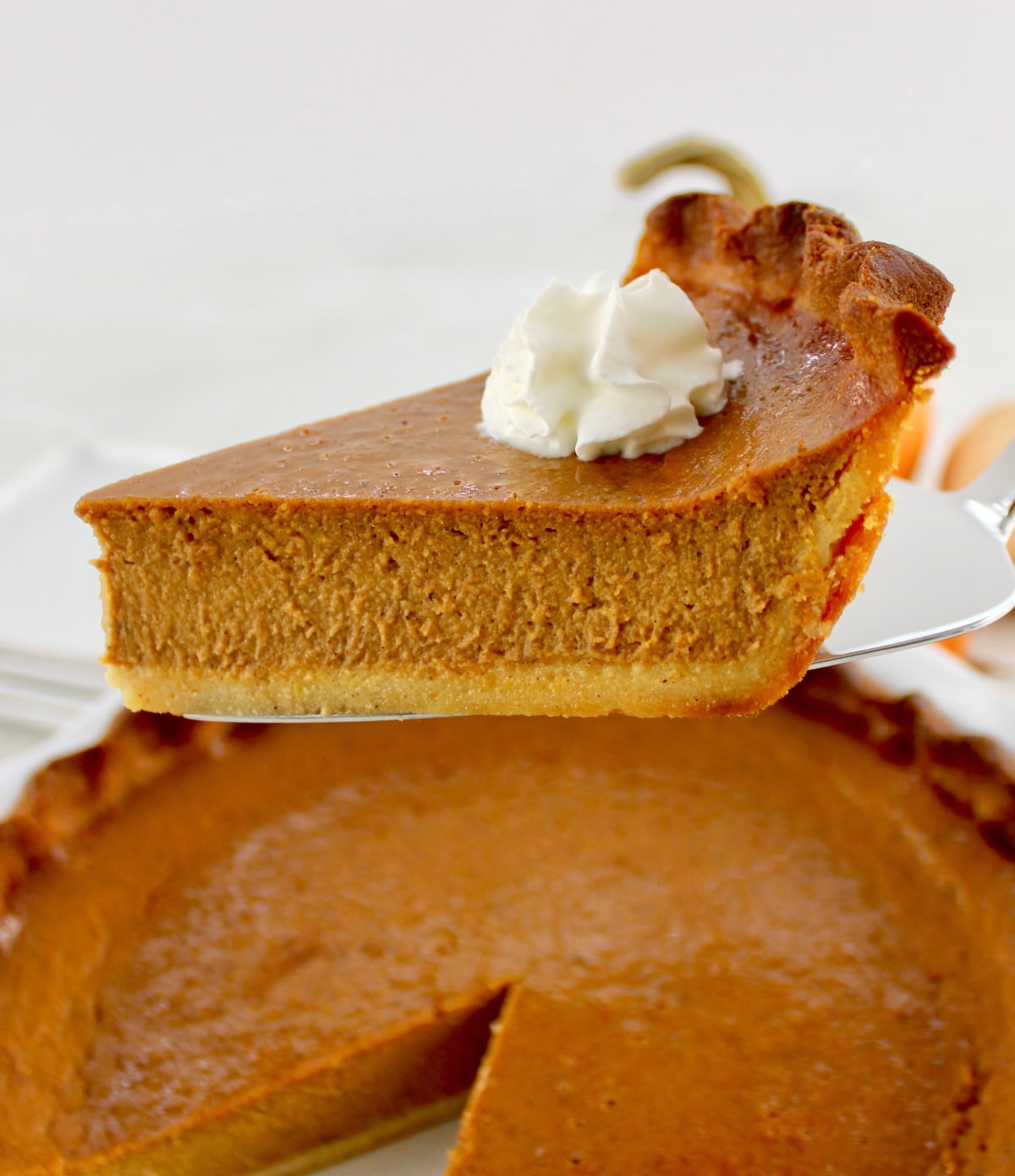 closeup of slice of Keto Pumpkin Pie with whip cream on top