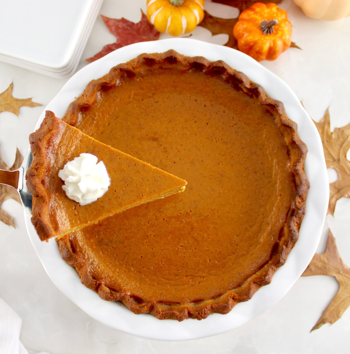 overhead view of Keto Pumpkin Pie with slice being held up over pie