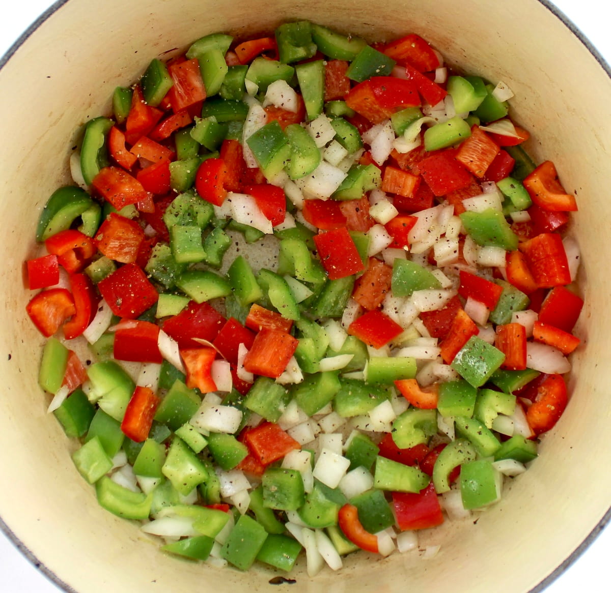 chopped bell peppers and onions in dutch oven