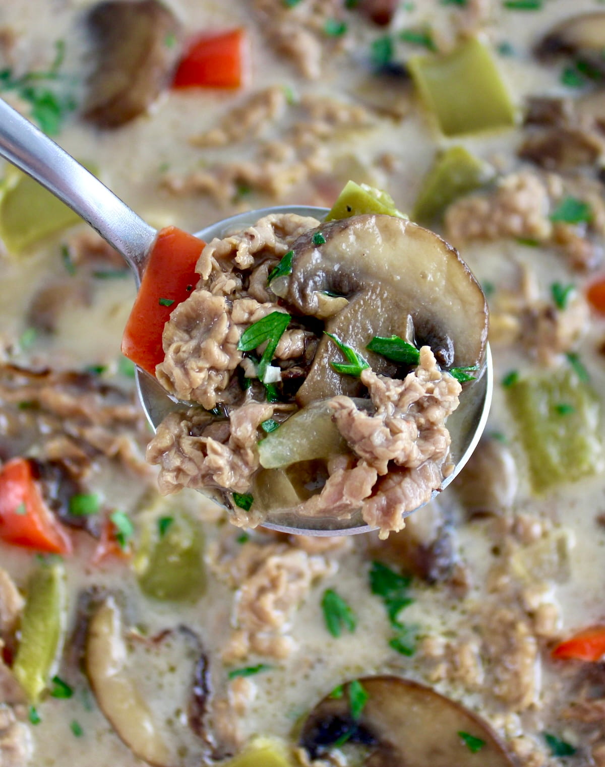 spoonful of Philly Cheesesteak Soup held up over bowl