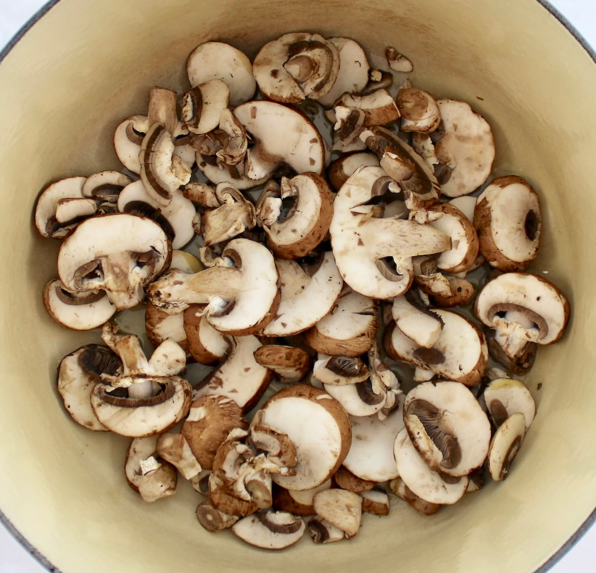 raw sliced mushrooms in dutch oven