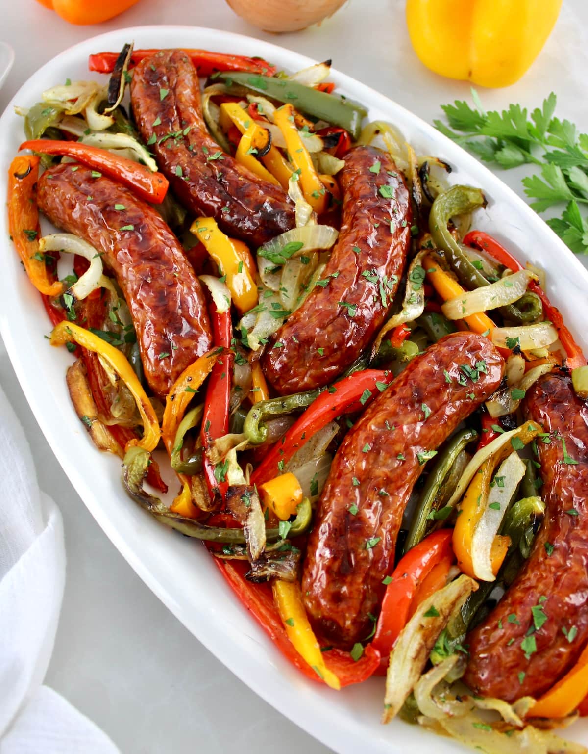 Sheet Pan Sausage and Peppers on white oval platter