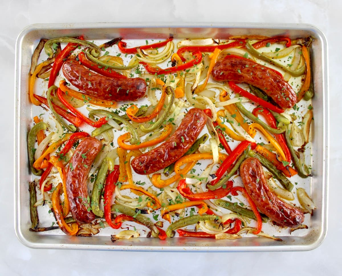 Sheet Pan Sausage and Peppers on baking sheet with chopped fresh parsley on top
