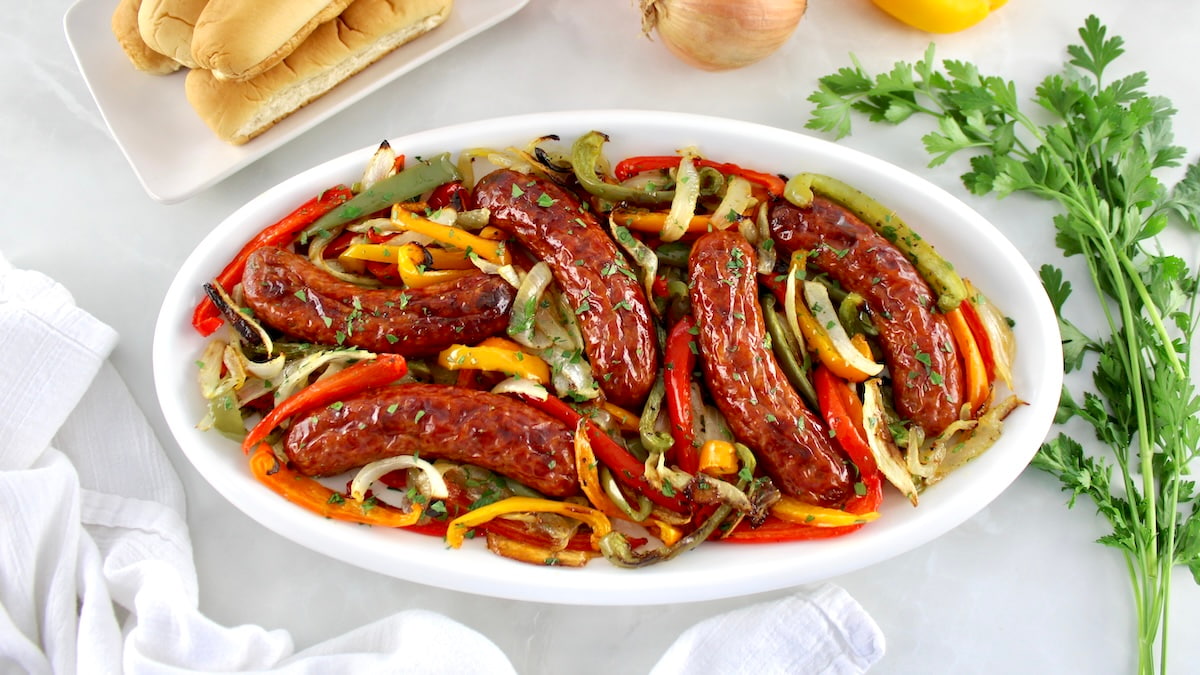 overhead view of Sheet Pan Sausage and Peppers on white oval platter